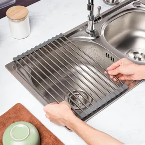 Roll-up dish drying rack detail showing stainless steel bars and silicone edges over sink.