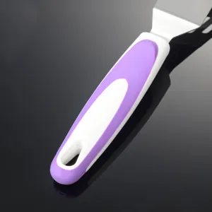 Edelstahl Küchenspatel Griff Detail, ergonomisches weißes und violettes Design, Nahaufnahme.