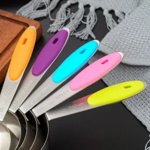 Colorful stainless steel measuring cups and spoons set with silicone handles for baking.