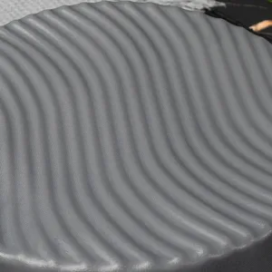 Detail shot of the grey round silicone cake mold featuring a wave texture for baking.