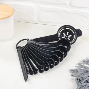 Vue détaillée d'un ensemble de cuillères à mesurer en plastique noir avec séparateur d'œufs.