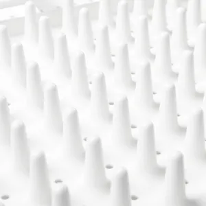 Vista detallada de la superficie de un escurridor de platos de plástico blanco con picos.