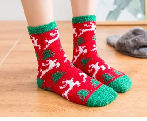 Detail shot of thick coral fleece Christmas home socks featuring cozy red and green winter design.