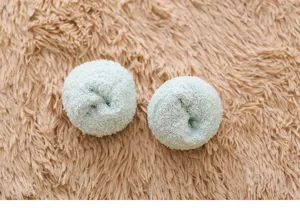 Close-up detail of soft coral fleece rolled fluffy socks in cozy warm winter style texture.