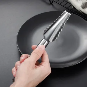 Herramienta de cocina de acero inoxidable para escamar pescado con borde dentado útil.