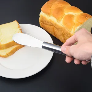 Detailaufnahme des rostfreien Edelstahl Butteressmessers beim Toast bestreichenszene.