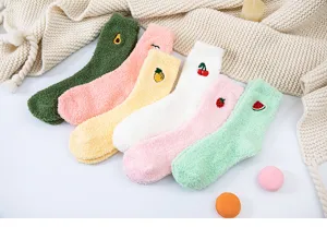 Close-up detail of cute fuzzy winter coral fleece socks with sweet fruit embroidery.