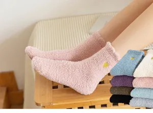 Soft fuzzy coral fleece socks detail view featuring cute gold heart embroidery and cozy texture.