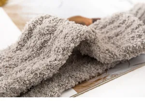 Soft fuzzy coral fleece winter warm socks detail, thick cozy sleep socks texture close up.
