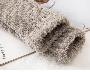 Close-up detail shot of fuzzy coral fleece winter thermal sleeping socks with thick texture.