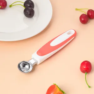 Stainless steel fruit melon baller spoon with red white handle kitchen gadget detail view.