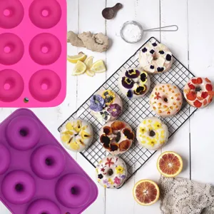 Detailansicht von 6er Silikon Donutformen in Rosa und Lila, dekoriert mit süßem Gebäck.