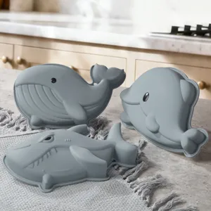 Vista dettagliata di stampi in silicone marini con forme di balena e squalo per dolci.