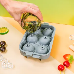 Detailed view of grey silicone sphere ice mold tray with 6 cavities being filled with water.