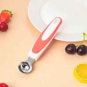 Detail view of a stainless steel fruit melon baller with red white handle, perfect for kitchen use.