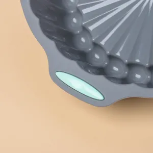 Silicone cake mold detail, grey and mint green baking pan close-up, non-stick kitchenware tool.