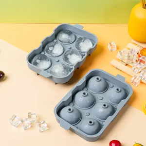 Detailed view of grey silicone ice ball maker mold with clear round ice spheres for home kitchen.