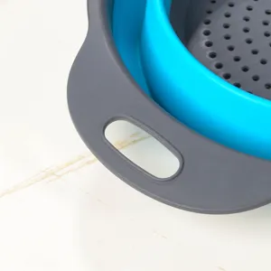 Détail de la passoire de cuisine pliable en silicone, structure en plastique et poignée.