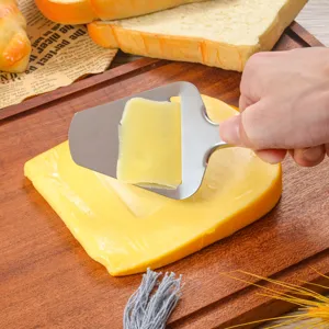 Stainless steel cheese slicer detail view showing cutting process on a wooden board.