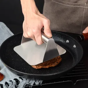Stainless steel burger press detail view, showing the sturdy handle and smooth pressing surface.