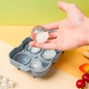 Silicone ice cube tray detail showing flexible mold and clear round sphere ice maker tool.