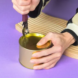 Primer plano del abrelatas portátil de acero inoxidable en acción, detalle de cocina.