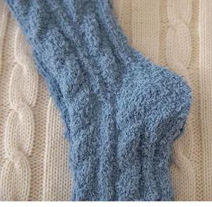 Detailed shot of thick cozy blue fuzzy cable knit winter socks showing soft coral fleece texture.