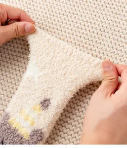 Close-up detail showing the high elasticity and soft fuzzy texture of coral fleece winter socks.