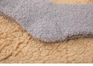 Nahaufnahme Detailansicht weicher grauer Korallenfleece kuscheliger Wintersocken Textur.