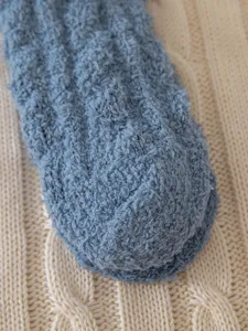Cozy blue fluffy winter sleep sock detail close-up, thick thermal coral fleece knit texture.