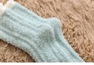 Close-up detail of winter thick coral fleece socks with cozy cable knit texture for women.