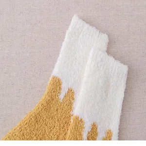 Close-up detail of thick coral fleece winter home socks, soft and warm fabric texture.