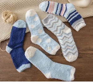 Cozy blue fuzzy socks detail, soft coral fleece winter sleep socks texture pattern display.