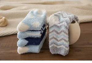 Cozy coral fleece winter socks detail, soft fuzzy fabric stack and elegant display prop.