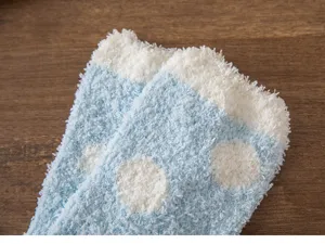 Detail view of blue and white polka dot plush coral fleece socks, soft and warm for winter home.
