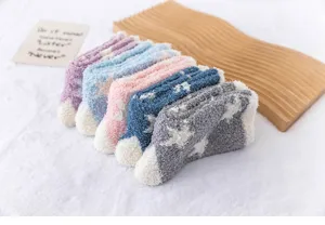 Détail de chaussettes duveteuses en polaire corail épaisse avec joli motif d'étoiles.