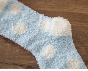 Soft coral fleece winter socks detail, cozy thick blue polka dot sleep socks texture.