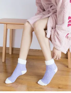 Detailed shot of thick fluffy winter sleep socks in purple and white color block design.