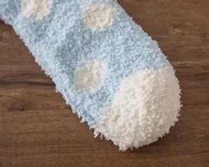 Soft fluffy fleece sock detail showing cozy blue texture and white polka dots for home comfort.