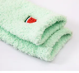 Close up of green coral fleece sleeping socks with cute watermelon embroidery detail.