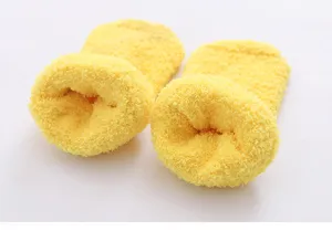 Dettaglio di calzette gialle in pile corallo, consistenza morbida e calda per il massimo comfort.