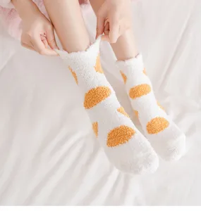 Close-up detail of fluffy coral fleece winter socks with cute yellow spots, soft and warm.