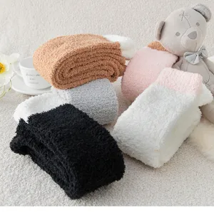 Close-up of soft cozy coral fleece fuzzy socks in various colors with cute plush bear decor.