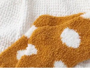 Detail view of cozy yellow coral fleece thermal socks with white polka dots, soft plush texture.