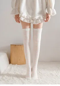 Fluffy coral fleece long socks detail showing soft texture and cozy pink stripe design.