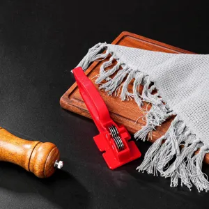 Detail shot of a red compact household knife sharpener for quick kitchen tool maintenance.
