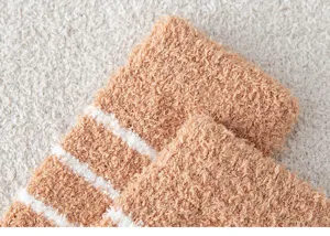 Close-up detail of soft coral fleece winter socks with cozy texture and stylish white stripes.