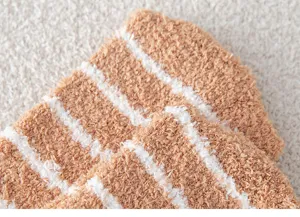 Close-up detail of soft coral fleece winter socks showing plush texture and striped design.