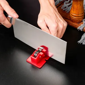 Detailed view of household knife sharpener in action, sharpening kitchen cleaver effectively.