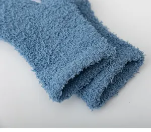 Close-up detail of winter thick coral fleece cozy sleep socks in soft blue solid color.